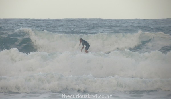 Surfing the fierce waves at Hot Water Beach 