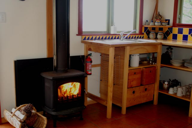 Hairy Hobbit Eco Cottage - kitchen and fire place